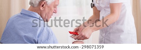 Nurse giving some medications to elder man