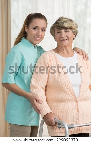 Photo of old lady with zimmer and nice nurse