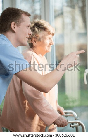 Young man and older woman looking through the window