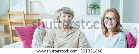 Elder lady with carer sitting on a couch