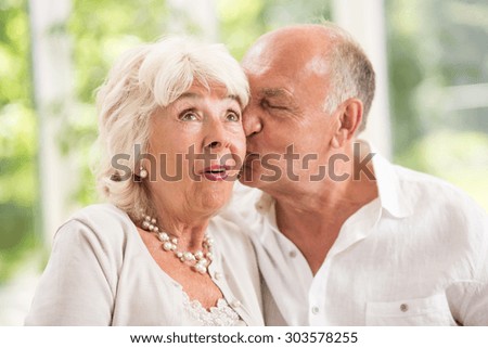 Senior husband kissing his wife on the cheek