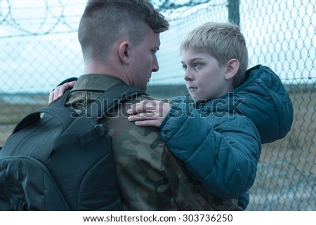 Worried son saying goodbye to his military father