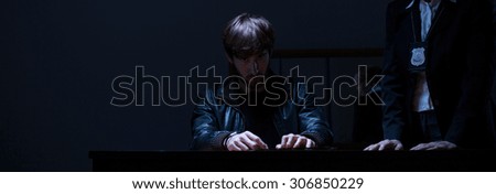 Policewoman questioning man in a dark room