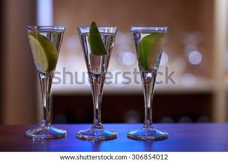 Photo of three drinks with lime standing on bar