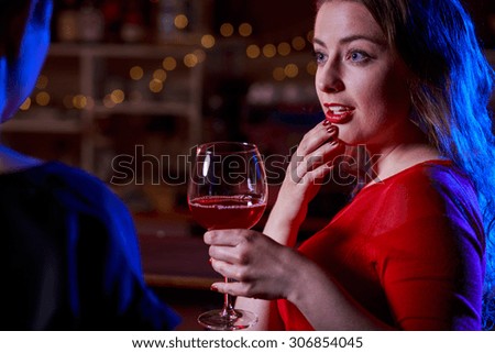Portrait of attractive woman at bar holding glass of wine