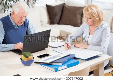 Photo of two elderly people having work at home