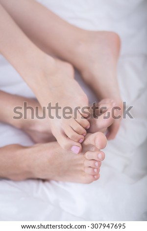 Close up of feet of romantic couple lying in bed