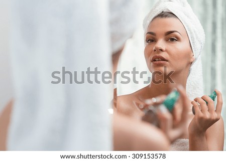 Young beauty woman applying perfume after bath