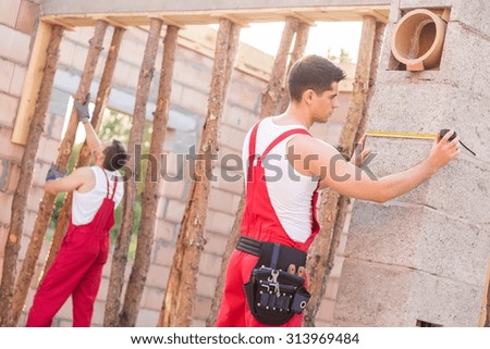 Young construction workers at house construction site