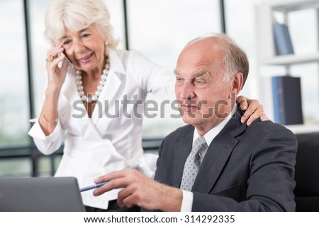 Elder businessman is pointing on the computer