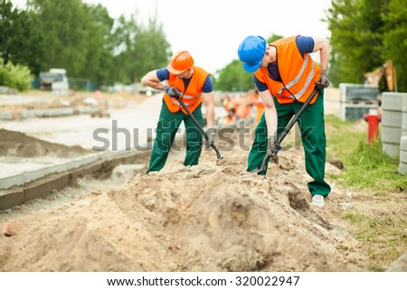 Image of construction workers digging on a road