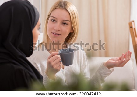 Picture of two female friends talking and drinking coffee