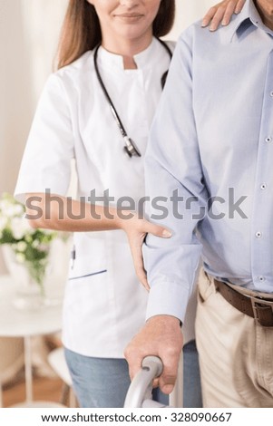 Young nurse is taking care of elder man