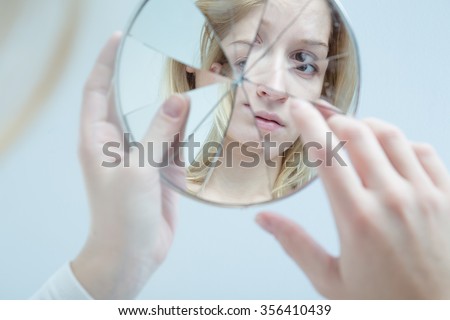 Insecure pretty young woman holding broken mirror 商業照片 © 