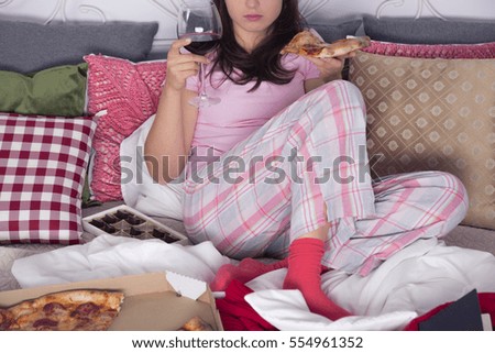 Woman sitting on couch, eating pizza and drinking wine Foto stock © 