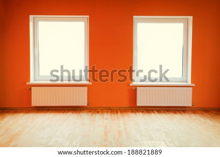 Empty orange room with two windows