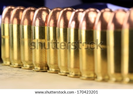 A row of 45 caliber ammunition copper plated bullets with brass slugs