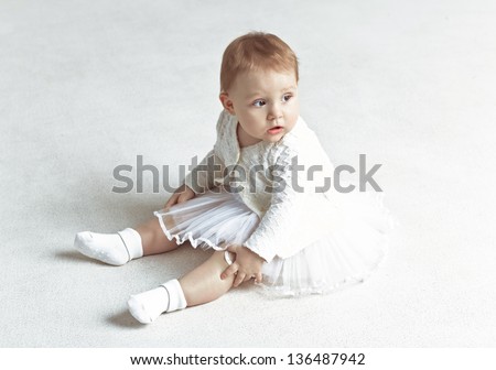 Little girl - ballerina sitting on the floor