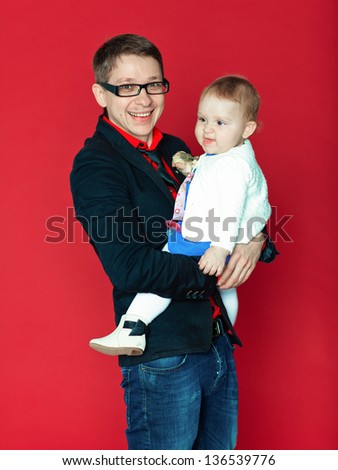 The father holds the little daughter in his arms