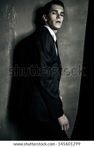 Strong businessman with grey wall on the background