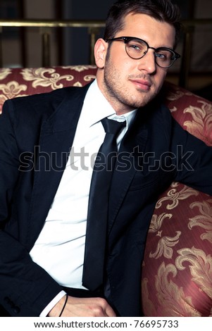 Stylish man in suit and glasses sitting