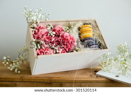 Carnation flowers in a box with a macaroon