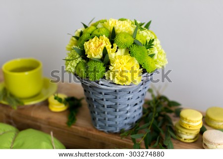 Beautiful bouquet of yellow carnation in basket on bright background