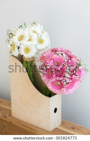 Pink and white gerbera bouquets in a wooden box