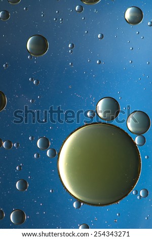 Oil and water abstract in blue, gold and silver, giving the impression of planets or rising bubbles