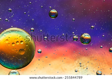 Oil and water abstract in yellow, red, blue and gold, giving the impression of planets