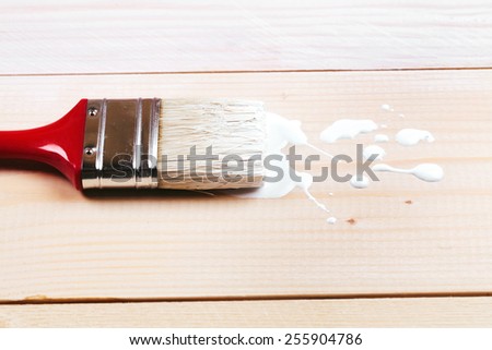 Brush painting wooden furniture with white color, close up
