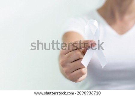 White January, mental health awareness campaign. Woman holding a white ribbon.