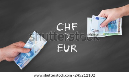 Swiss Franc and Euro banknotes on black board - Swiss Franc is stronger than Euro