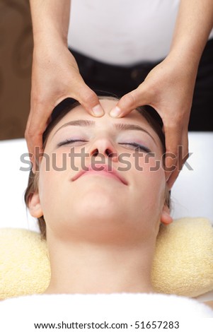 Beautiful young woman receiving head massage, shallow depth of field