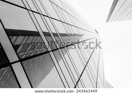 Glass surface of skyscrapers view in district of business centers with reflection on it, black and white