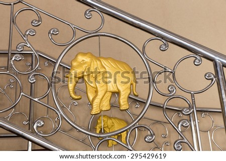 Golden elephant on stainless steel handrails.