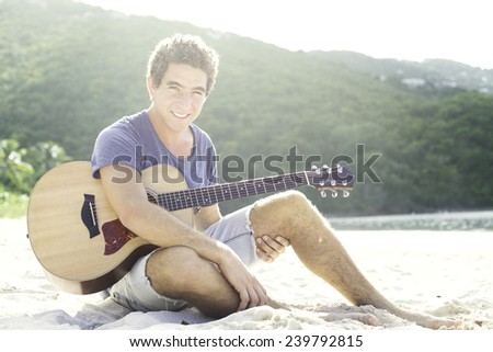 Guy playing guitar on the beach