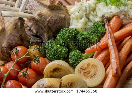 Roast Rack of Lamb with roasted mixed vegetables, onions, carrots, tomatoes, broccoli and mashed potato