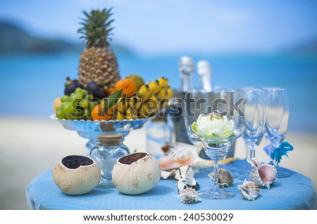 Wedding table with fruit and champagne on the background of the sea