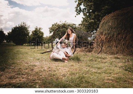 couple clothed in linen near haystacks in village