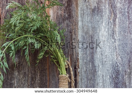 Bunch of fresh carrots with green leaves on a wooden background a place for inscription