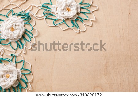 lace doily with flowers white and green on a wooden background