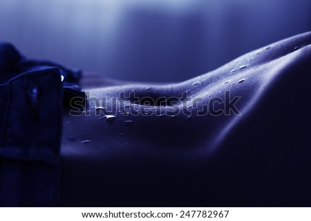 closeup of women abdomen and flat tummy with water drops. sexy body in shorts