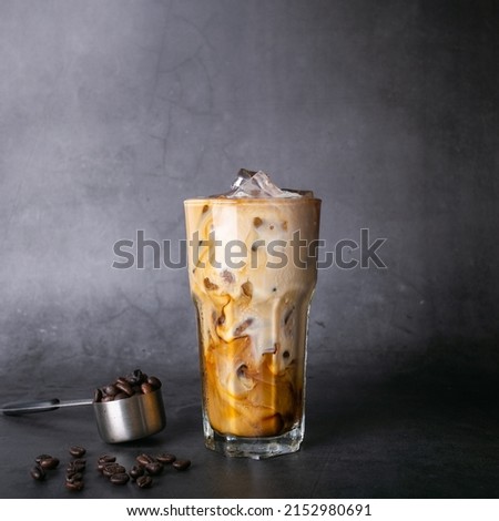 iced latte coffee into a transparent glass with ice. and roasted coffee beans on a black background studio photo Photo stock © 