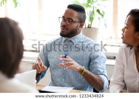 African American businessman, leader, coach speaking about ideas, new project, business strategy at briefing, company meeting to colleagues group, team, team building training, explaining tasks Stock foto © 