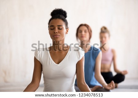 Similar – Image, Stock Photo Group of calm focused women and men practicing yoga with trainer standing in balance pose and stretching body in studio