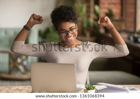 Excited happy african american woman feeling winner rejoicing online win got new job opportunity, overjoyed motivated mixed race girl student receive good test results on laptop celebrating admission Imagine de stoc © 