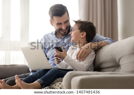 Image, Stock Photo Father and son using digital tablet together at night in bed