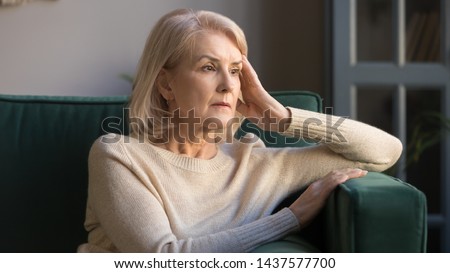 Pensive thoughtful middle aged lady looking away sit alone at home feel anxious lonely, sad depressed melancholic old mature woman suffer from sorrow grief thinking of problem suffer from solitude Stock foto © 