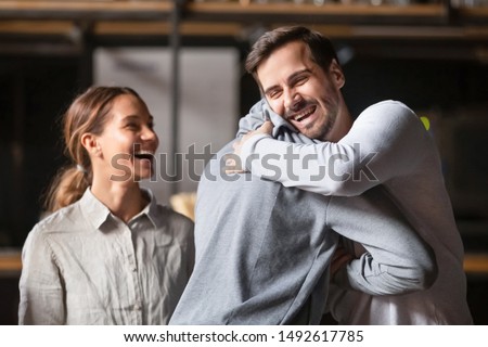Happy diverse male buddies embracing greeting in cafe, excited millennial african and caucasian men best friends hugging laughing welcoming at reunion meeting in bar, multiracial friendship concept